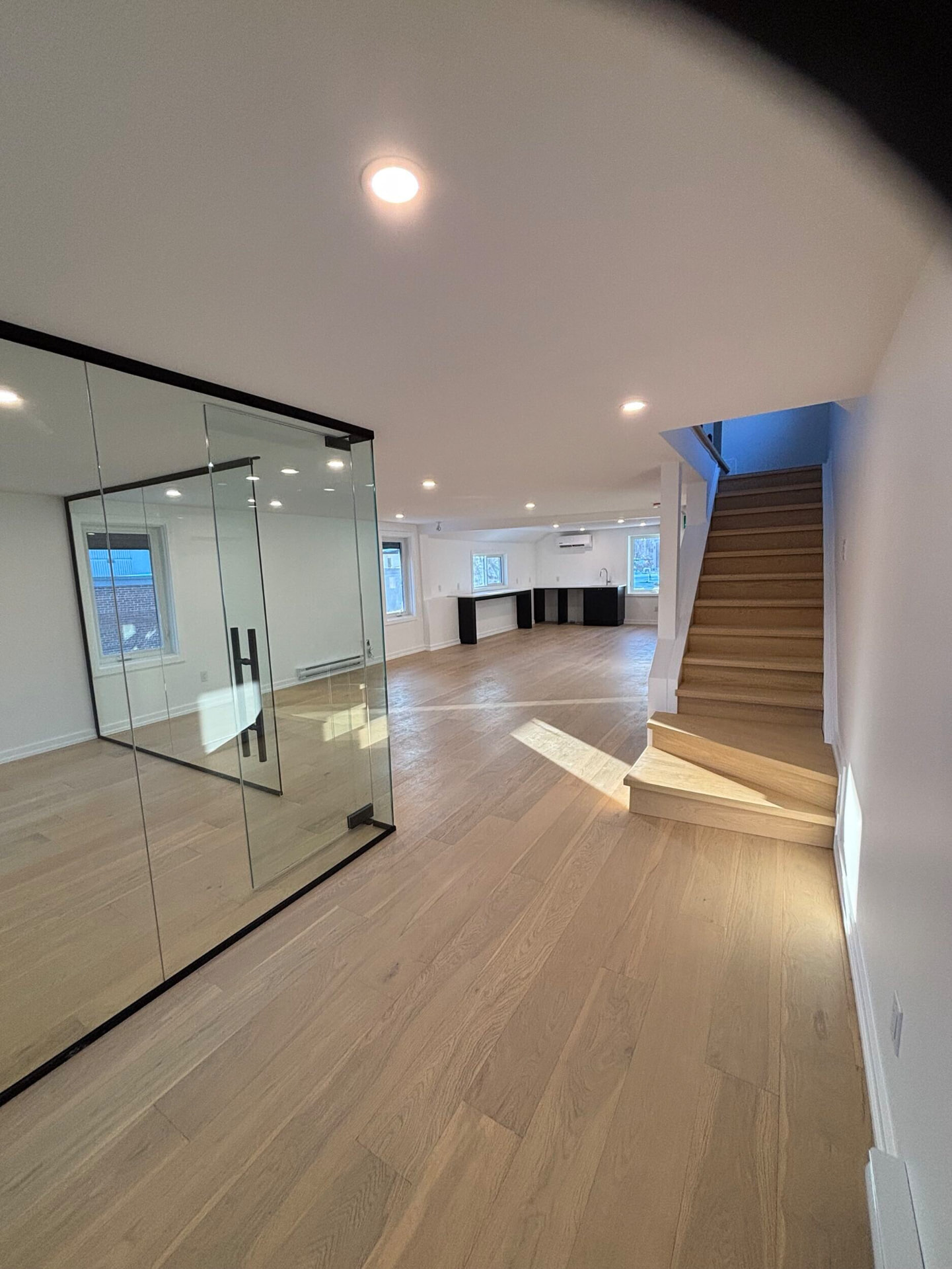 Finished multi-unit interior with glass partition and white oak stair