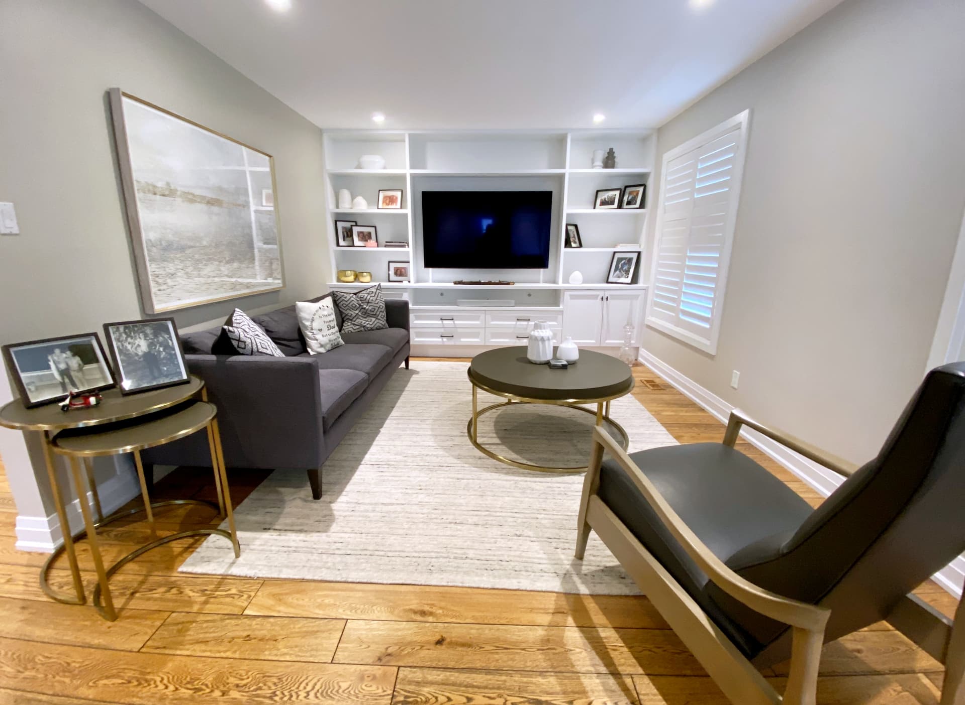 Custom white built-in shelving and cabinetry surrounding a wall-mounted television