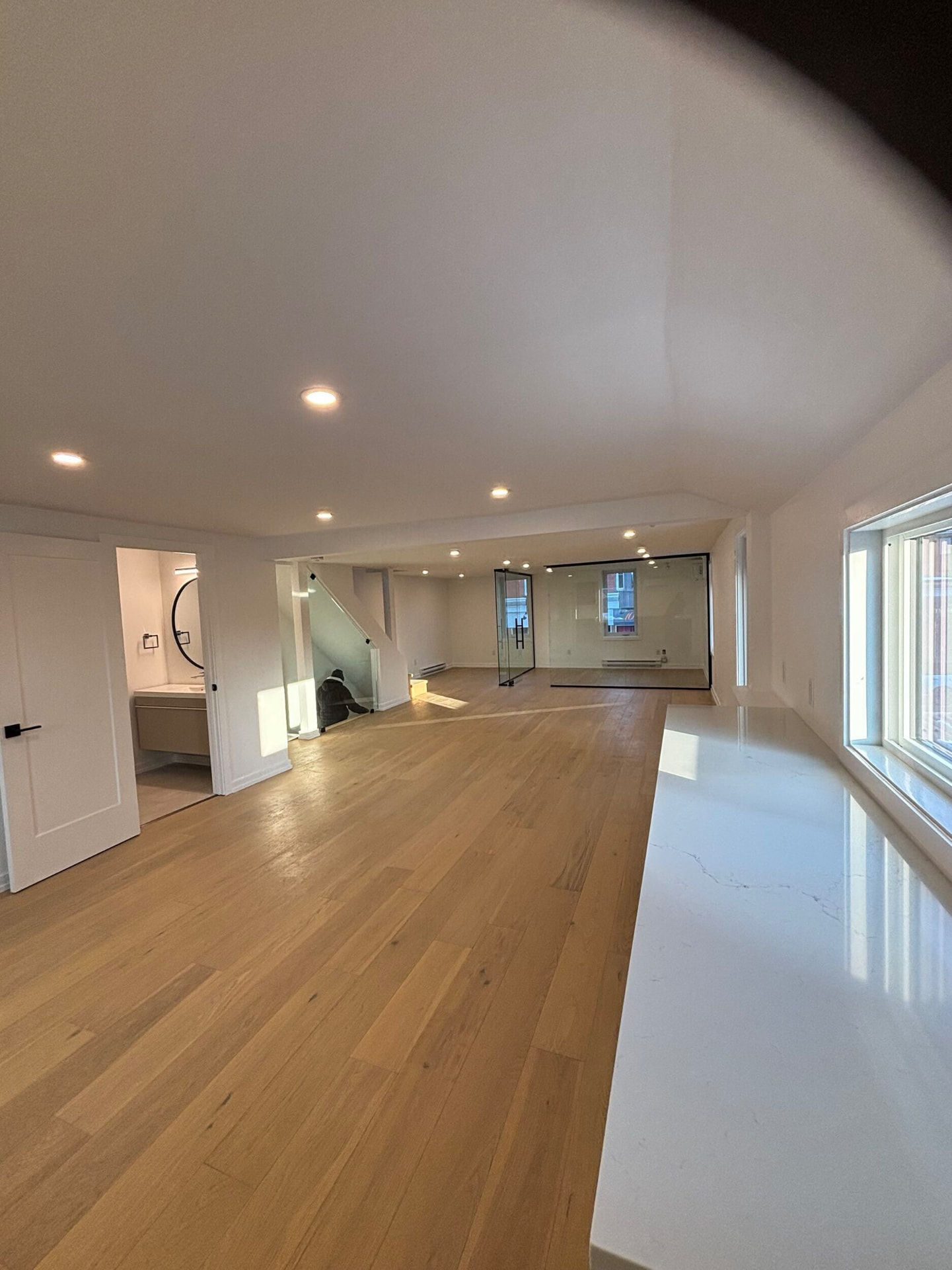 Finished self-contained unit with oak floors and a glass-walled room