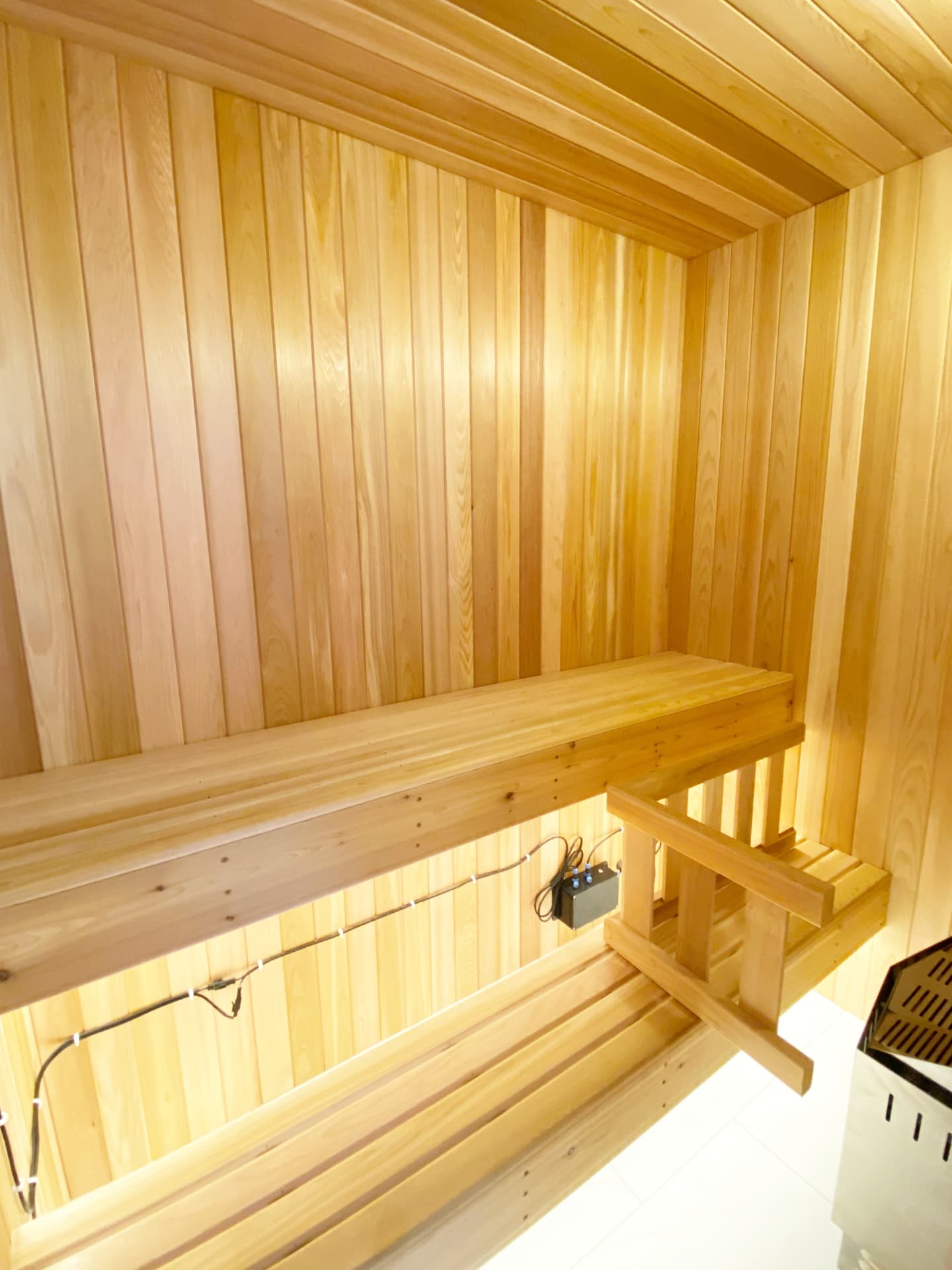Interior of a western red cedar sauna with two-tier bench and warm under-bench lighting